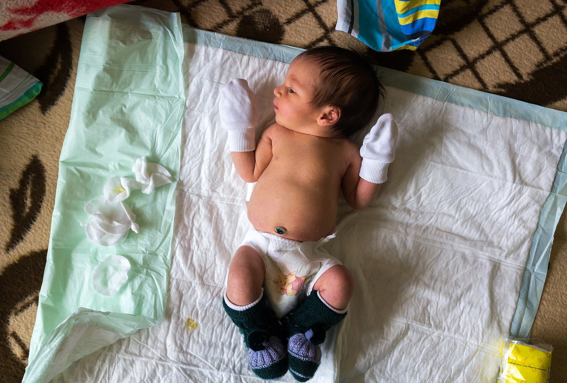 Babyverzorging op een aankleedkussen (stockfoto)