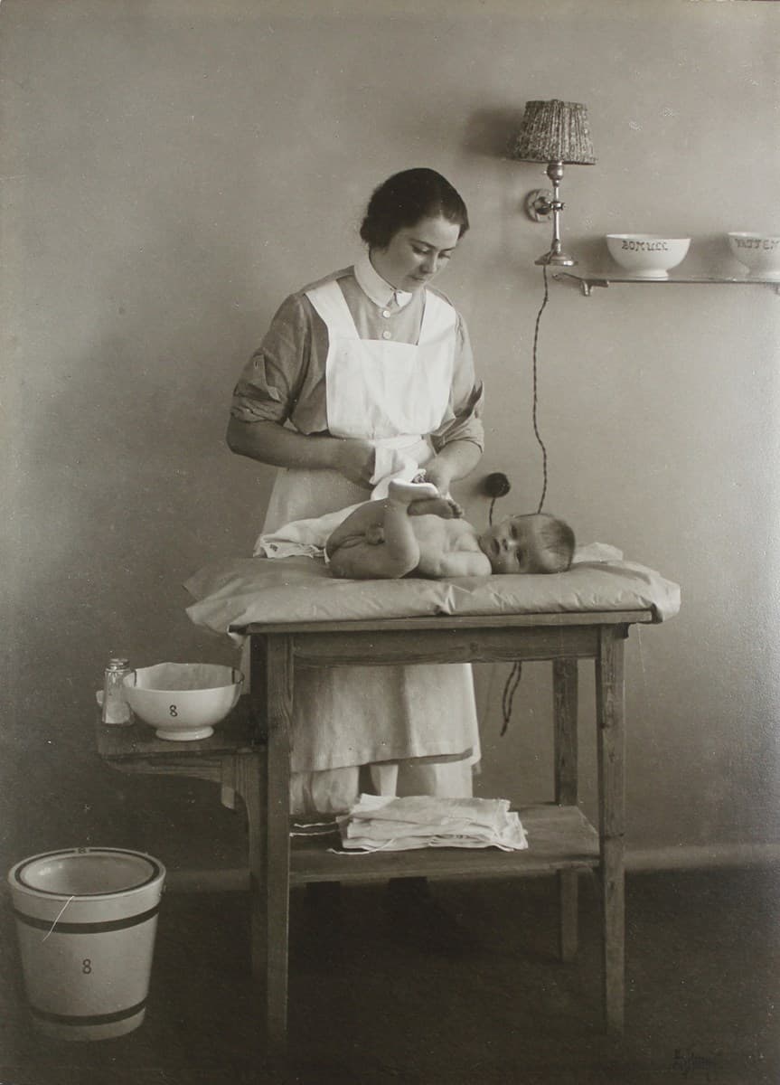 Luier verschonen op een aankleedkussen (stockfoto)